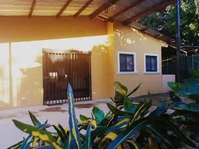 a house with a gate and some plants at Casa Binisa Fresca y agradable in Liberia