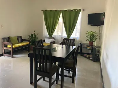 a dining room with a table and chairs and a couch at Casa Binisa Fresca y agradable in Liberia