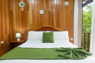 a bedroom with a bed with a wooden wall at Casas Clusia in Monteverde Costa Rica