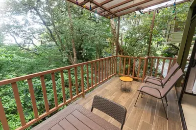 a porch with two chairs and a table on a deck at Casas Clusia in Monteverde Costa Rica