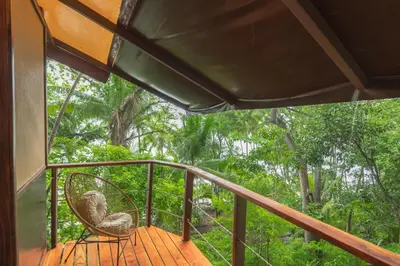 a balcony with a chair on a wooden deck at Los Vivos Beachfront Experience in Pochote