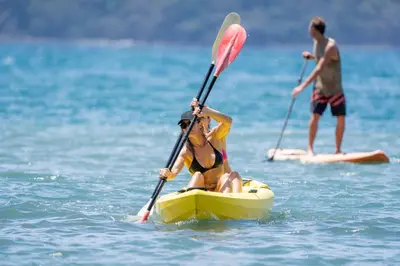 a woman is sitting on a kayak in the water at Los Vivos Beachfront Experience in Pochote
