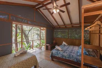 a bedroom with a bed and a ceiling fan at Los Vivos Beachfront Experience in Pochote