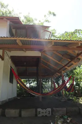 a hammock hanging under a roof of a building at Amaya's Hostel in Jaloba