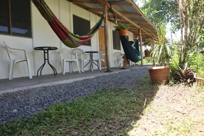a patio with chairs and hammocks on a house at Amaya's Hostel in Jaloba