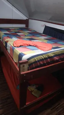 a bed with a colorful quilt on top of it at Amaya's Hostel in Jaloba