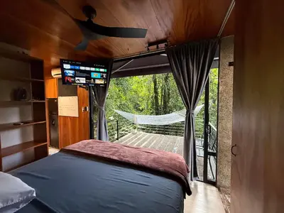 a bedroom with a bed and a large window at Sweet Jungle in Quesada