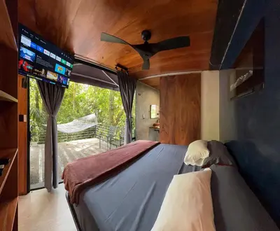 a bedroom with a bed with a ceiling fan at Sweet Jungle in Quesada