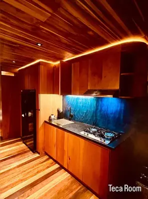 a kitchen with wooden cabinets and a stove top oven at Sweet Jungle in Quesada