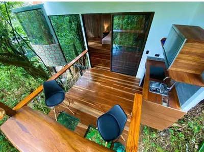 a wooden staircase with two chairs and a desk at Sweet Jungle in Quesada