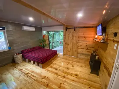 a living room with a red couch and wooden floors at Sweet Jungle in Quesada