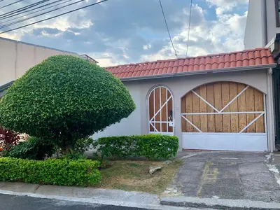 a house with a large garage with a large door at Room near Airport/ Cerca del Aeropuerto in Santiago Este