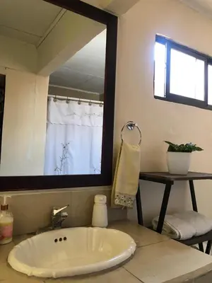 a bathroom with a large white tub and a mirror at Room near Airport/ Cerca del Aeropuerto in Santiago Este