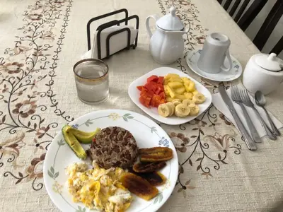 a table with two plates of breakfast food on it at Room near Airport/ Cerca del Aeropuerto in Santiago Este