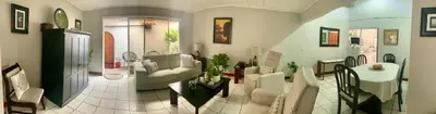 a living room with a couch and a table at Room near Airport/ Cerca del Aeropuerto in Santiago Este