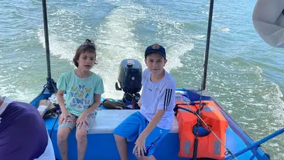 two young boys sitting on the back of a boat at Cabinas Chazu #2 in Quepos