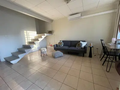 a living room with a couch and a staircase at Casa Buda 2 Liberia cerca del aeropuerto in Liberia