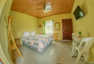 a bedroom with a bed and a table and a desk at Chongos Place in Fortuna