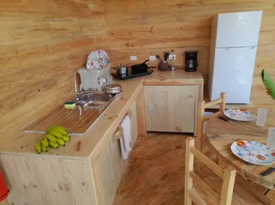 a kitchen with a counter with a sink and a refrigerator at Bungalows Baobab in San Isidro