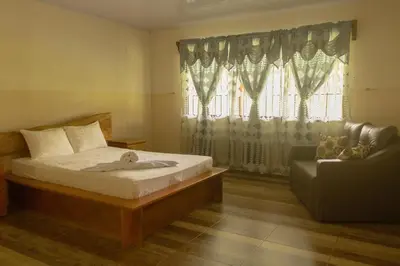 a bedroom with a bed and a couch and a window at Green House in Samen