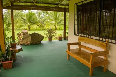 a porch with a bench and a large rock at Green House in Samen