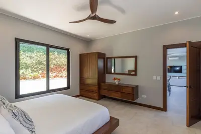 a bedroom with a bed and a ceiling fan at Casa Solaz - by Pura Villas in Dominical