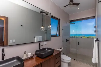 a bathroom with a sink and a shower and a mirror at Casa Solaz - by Pura Villas in Dominical