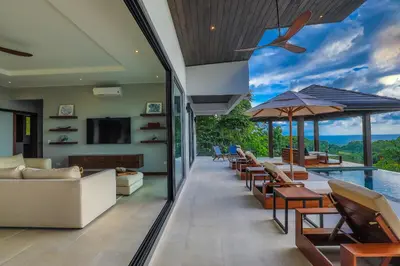 a living room with a pool and tables and chairs at Casa Solaz - by Pura Villas in Dominical