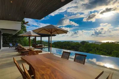 an outdoor dining area with a view of the ocean at Casa Solaz - by Pura Villas in Dominical