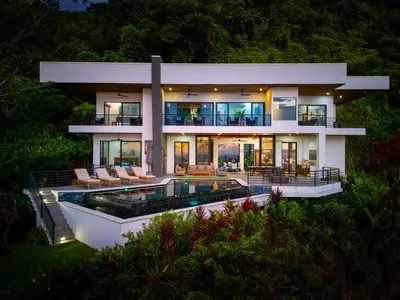 a large house with a swimming pool in front of it at Casa Amigos - By Pura Villas in Dominical