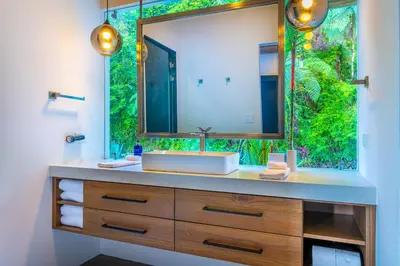a bathroom with a sink and a large mirror at Casa Amigos - By Pura Villas in Dominical