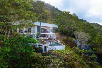 a building on a hill with a mountain at Casa Amigos - By Pura Villas in Dominical