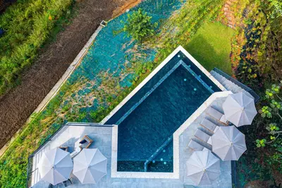 an overhead view of a swimming pool with umbrellas at Casa Amigos - By Pura Villas in Dominical