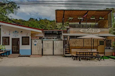 a building with a picnic table and an umbrella at Habitat Surf Glamp in Santa Teresa Beach