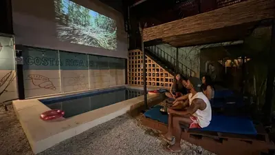 a group of people sitting around a swimming pool at Habitat Surf Glamp in Santa Teresa Beach