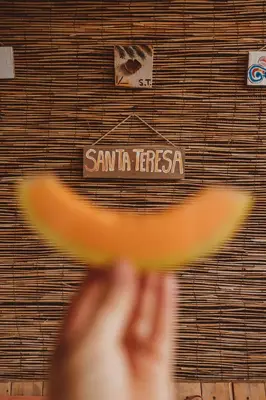 a person wearing a hat in front of a sign at Habitat Surf Glamp in Santa Teresa Beach