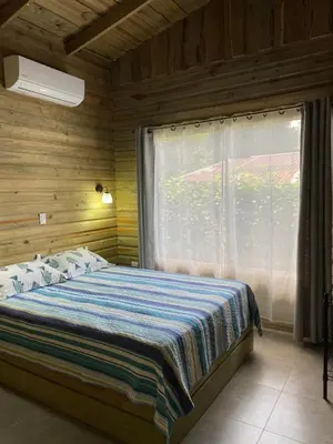 a bedroom with a bed with a large window at Cabaña ValFio Bahía Ballena in Uvita