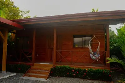 a wooden house with a porch and a window at Cabaña ValFio Bahía Ballena in Uvita