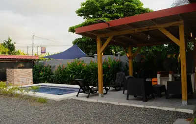 a patio with a table and chairs and a pool at Cabaña ValFio Bahía Ballena in Uvita