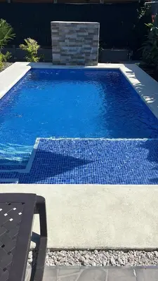 a swimming pool with blue water in a yard at Cabaña ValFio Bahía Ballena in Uvita
