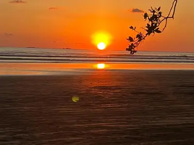 a sunset on the beach with the sun setting at Cabaña ValFio Bahía Ballena in Uvita