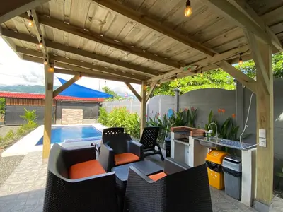 a patio with a pergola and a swimming pool at Cabaña ValFio Bahía Ballena in Uvita