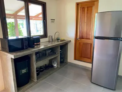 a kitchen with a stainless steel refrigerator and a counter at El Hostel del Patio in Tortuguero