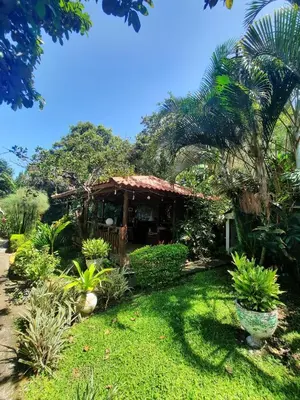 a house in a garden with a grass yard at Brillasol Airport Hotel in Alajuela City