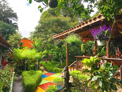 a garden with a colorful rug in front of a house at Brillasol Airport Hotel in Alajuela City