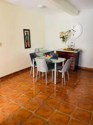 a dining room with a table and chairs on a tile floor at Sueños de Amor! Hermoso y Acogedor lugar in Quepos
