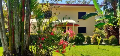 a house with a garden in front of it at Sueños de Amor! Hermoso y Acogedor lugar in Quepos