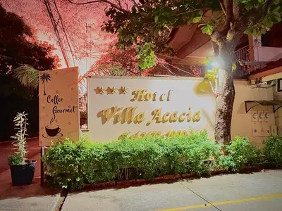 a sign for a hotel with a sign for a hotel while needed at Hotel Villa Acacia in Playa Hermosa