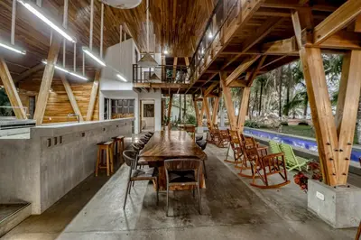 a dining room with a wooden table and chairs at Mangue House in Playa San Miguel