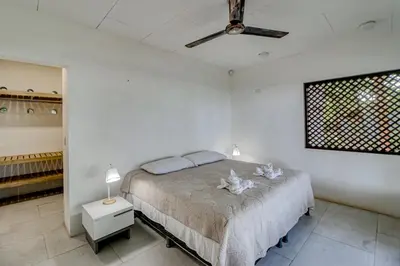 a bedroom with a bed and a ceiling fan at Mangue House in Playa San Miguel